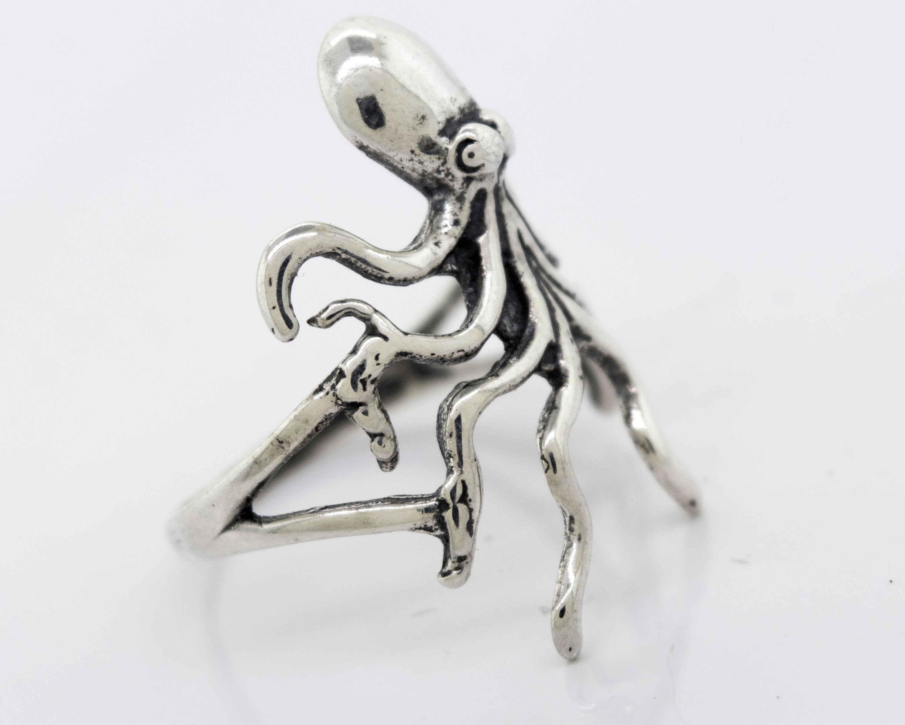 A Super Silver American Made Octopus Ring in the shape of an octopus on a white surface.