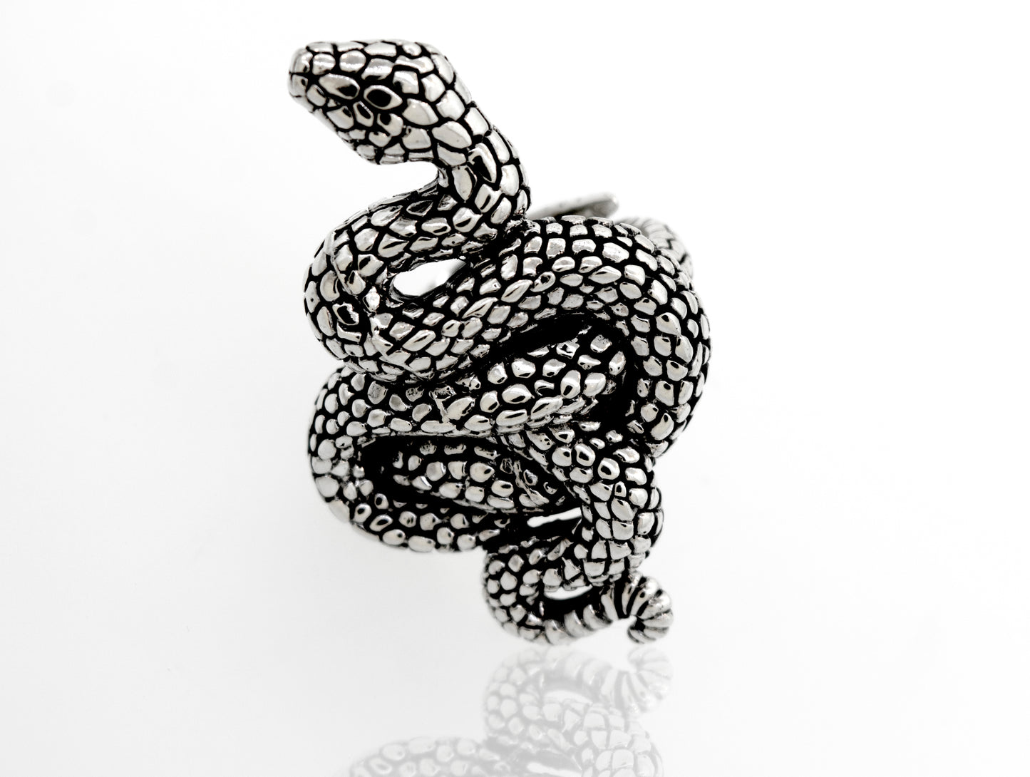 
                  
                    A Coiled Snake Ring by Super Silver, made of .925 Sterling Silver with an adjustable band, resting on a white surface.
                  
                