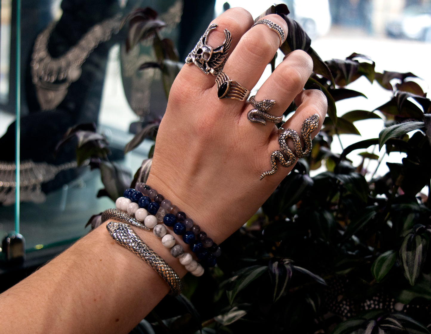 
                  
                    A woman's hand adorned with exquisite handcrafted Super Silver rings, featuring an adjustable size band, including the Online Only Exclusive Designer Snake Ring.
                  
                