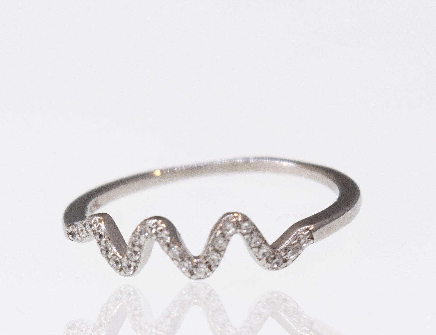 A white gold Wavy Pave Band engagement ring with diamonds on it.