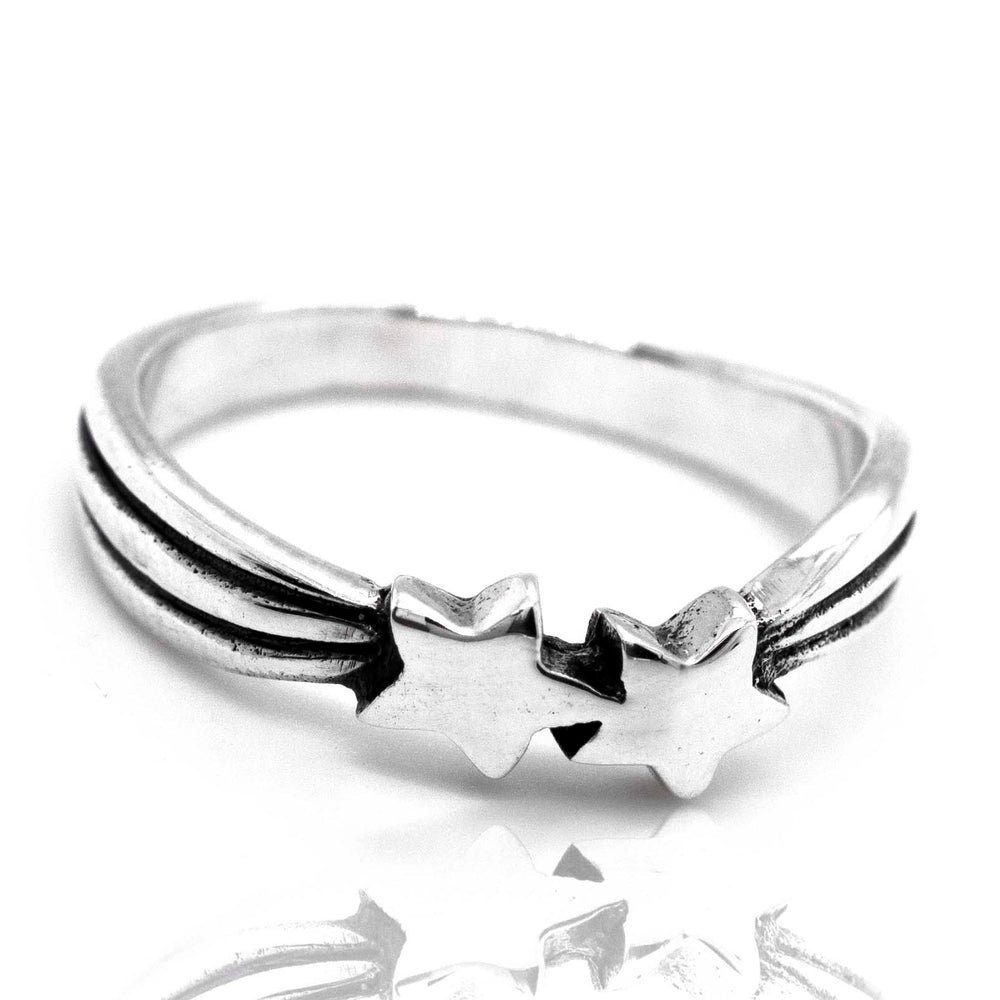 Double Shooting Star Ring with a sterling silver band, isolated on a reflective white surface.