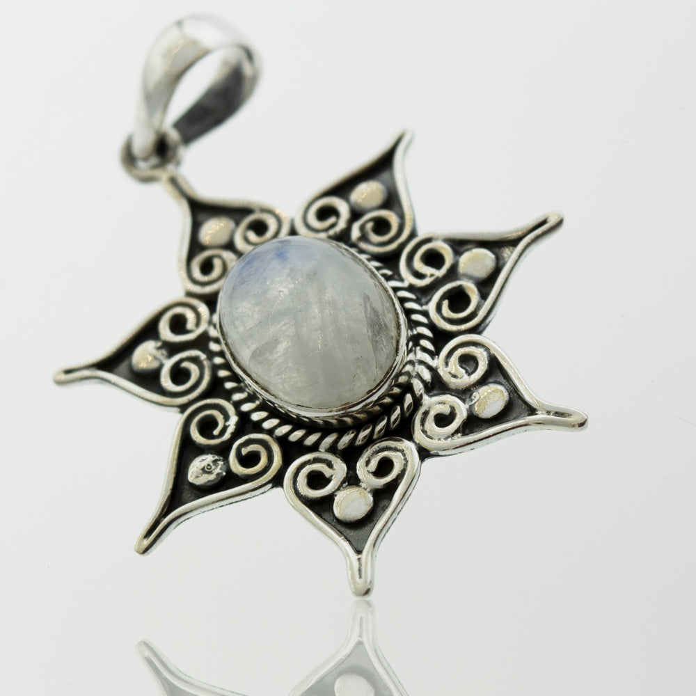 A Super Silver moonstone pendant with a flower star setting, adorned with delicate spirals.