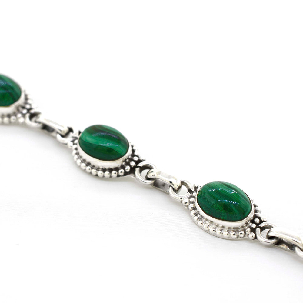 
                  
                    A Super Silver Oval Gemstone Bracelet With Ball Border with green gemstones on it.
                  
                