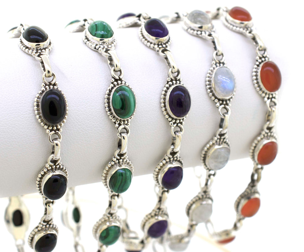 A set of Oval Gemstone Bracelets with different colored stones, all delicately crafted in sterling silver, branded as Super Silver.