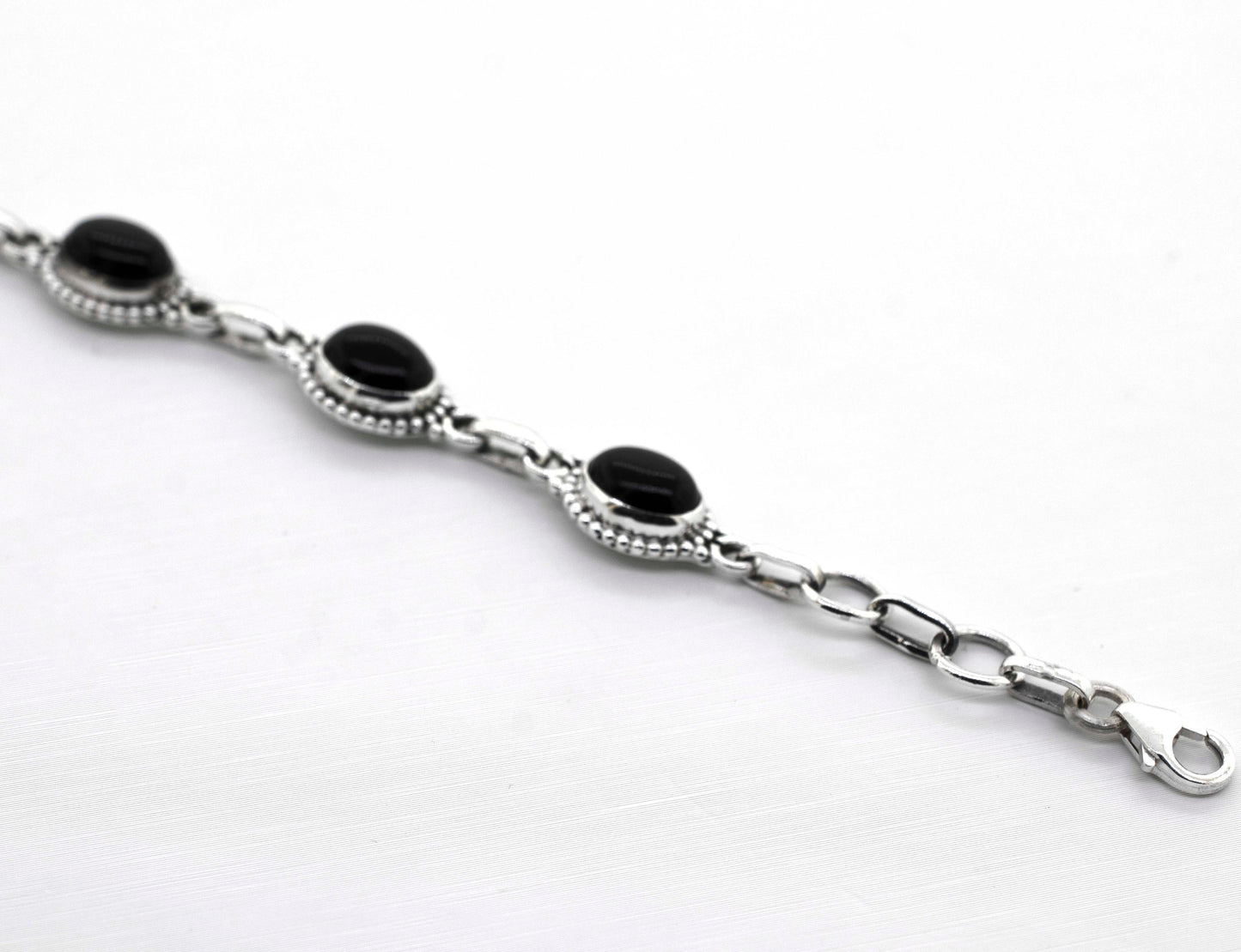 
                  
                    A Super Silver Oval Gemstone Bracelet With Ball Border on a white surface.
                  
                