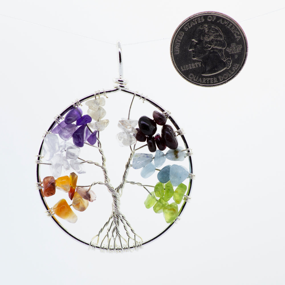 
                  
                    A Super Silver wire wrapped Tree of Life pendant adorned with stones and featuring a coin centerpiece.
                  
                
