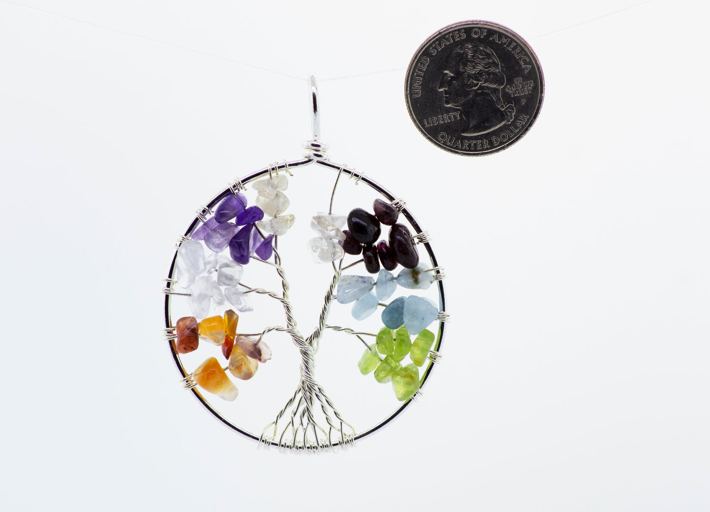 
                  
                    A Super Silver wire wrapped Tree of Life pendant adorned with stones and featuring a coin centerpiece.
                  
                