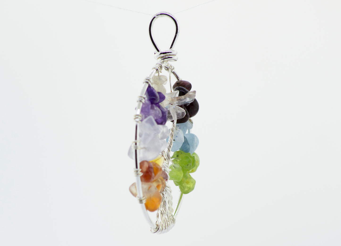 
                  
                    A vibrant Super Silver Wire Wrapped Tree of Life pendant intricately wire wrapped with colorful stones, hanging gracefully from a chain against a pure white background.
                  
                