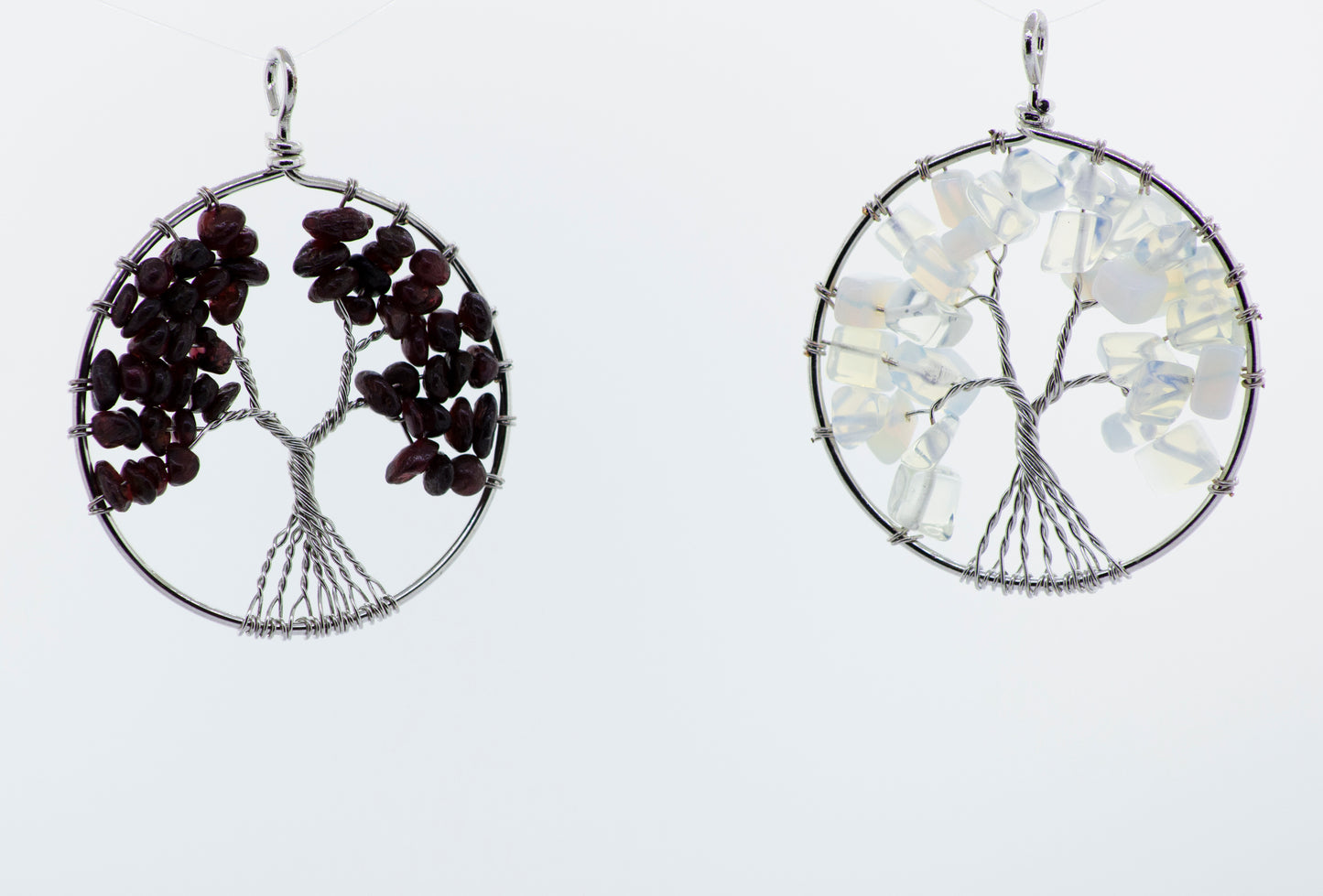 A pair of wire wrapped earrings with a Super Silver Wire Wrapped Tree of Life pendant.