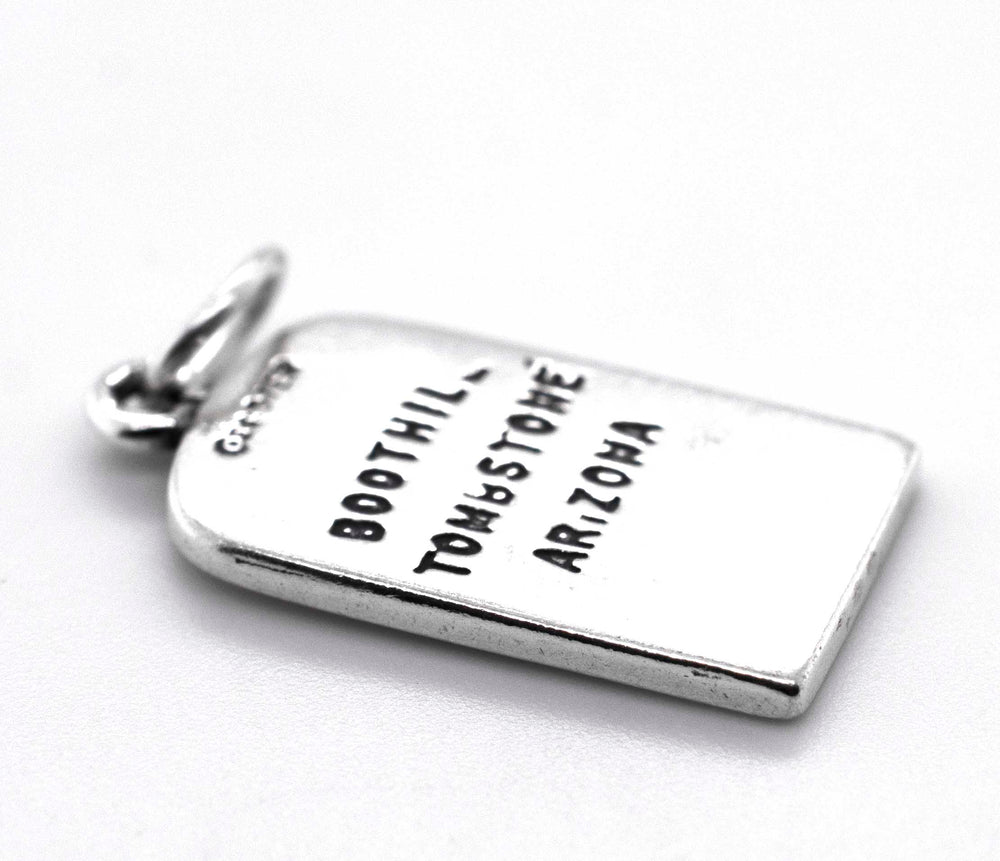 A silver charm with the words 