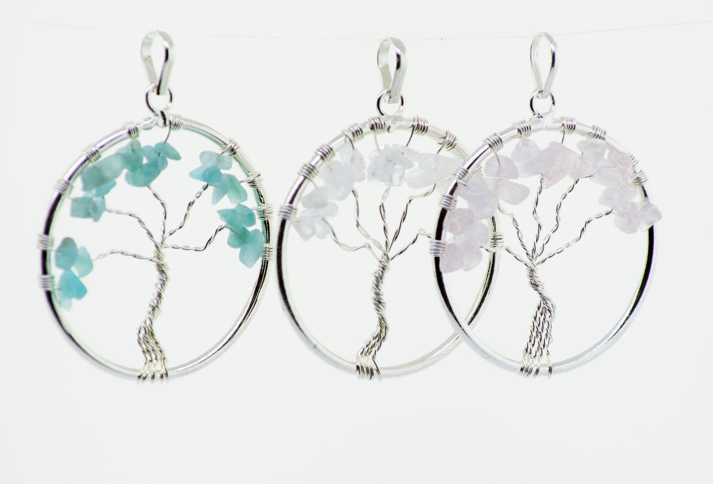 
                  
                    Three Wire Wrapped Tree of Life pendants with Stones hanging from a chain, made by Super Silver.
                  
                