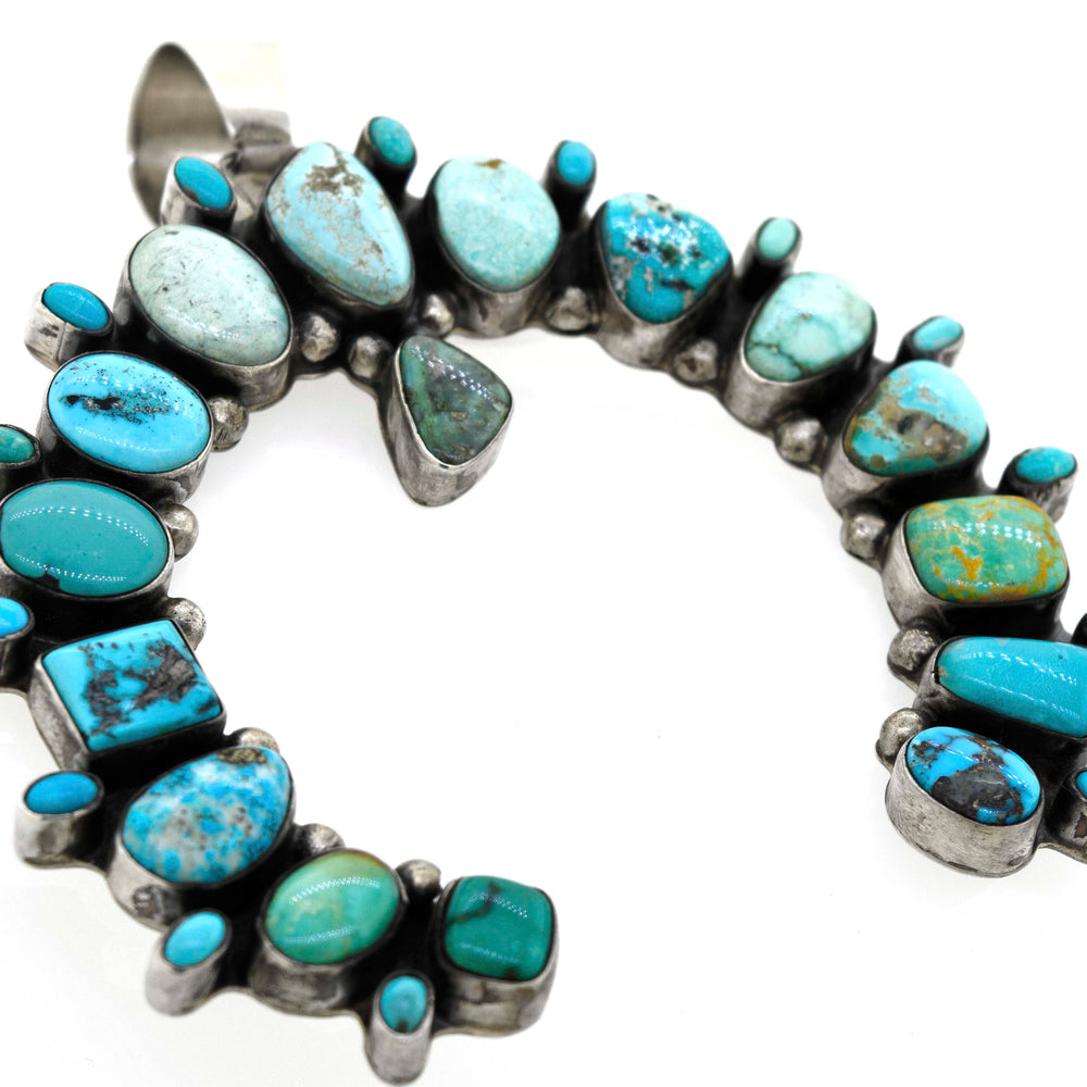 
                  
                    A Super Silver Stunning Handcrafted Naja Pendant necklace with turquoise stones on it.
                  
                
