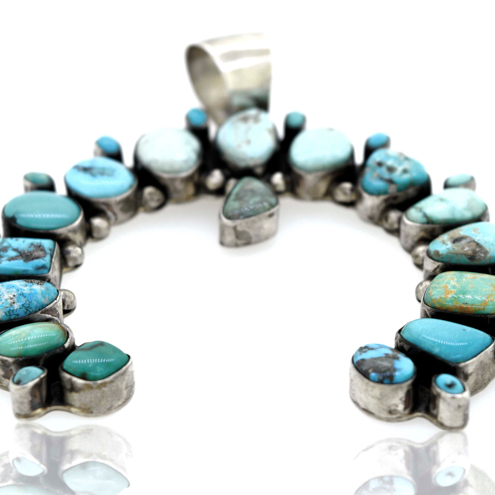 
                  
                    A Super Silver Stunning Handcrafted Naja Pendant adorned with turquoise stones.
                  
                