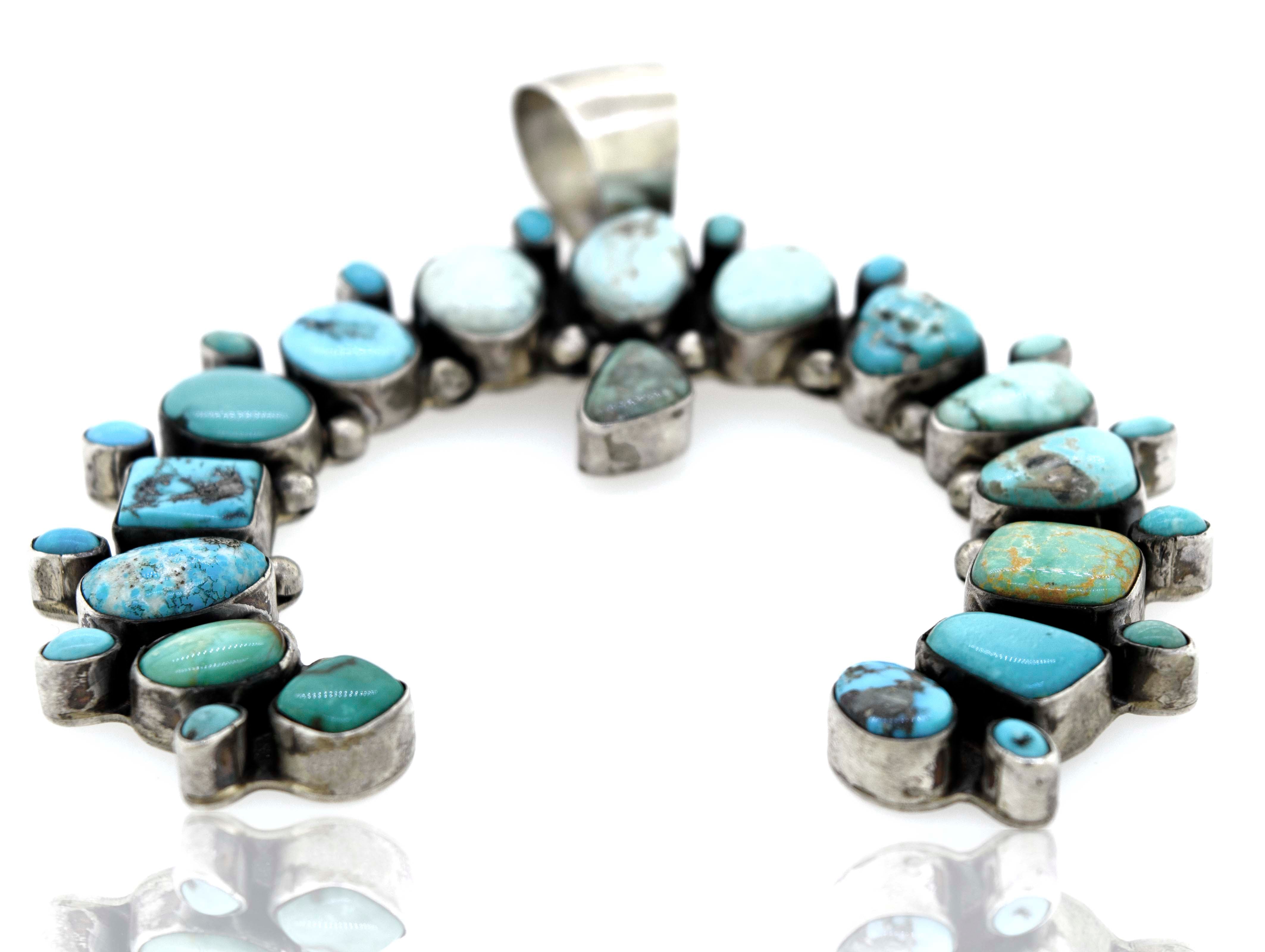 A Super Silver Stunning Handcrafted Naja Pendant adorned with turquoise stones.