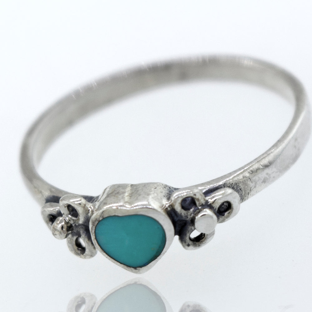 A sterling silver "Turquoise Heart Ring With Flower Designs" with a turquoise stone and a flower design.
