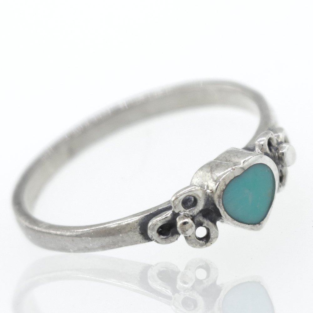 A sterling silver ring with a Turquoise Heart Ring With Flower Designs stone.
