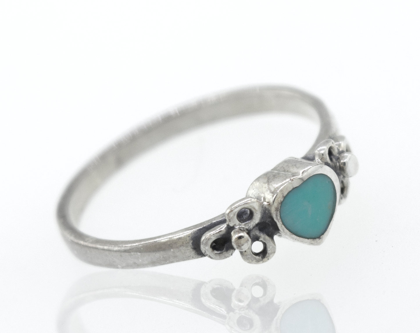 A sterling silver ring with a Turquoise Heart Ring With Flower Designs stone.