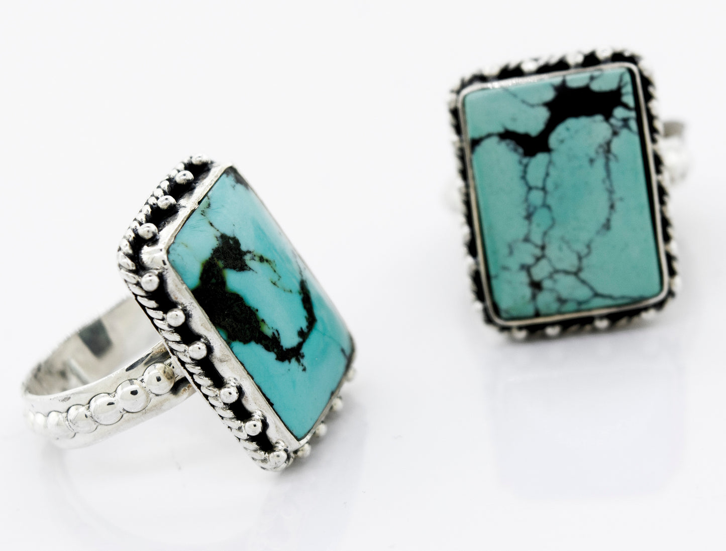 A pair of Rectangular Shape Natural Turquoise Rings with sterling silver bands, branded by Super Silver, on a white surface.