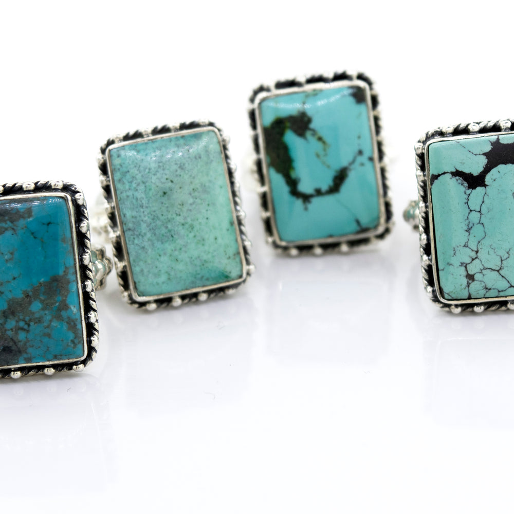 
                  
                    Four Rectangular Shape Natural Turquoise Rings With Ball Border set on a white surface from the Super Silver brand.
                  
                