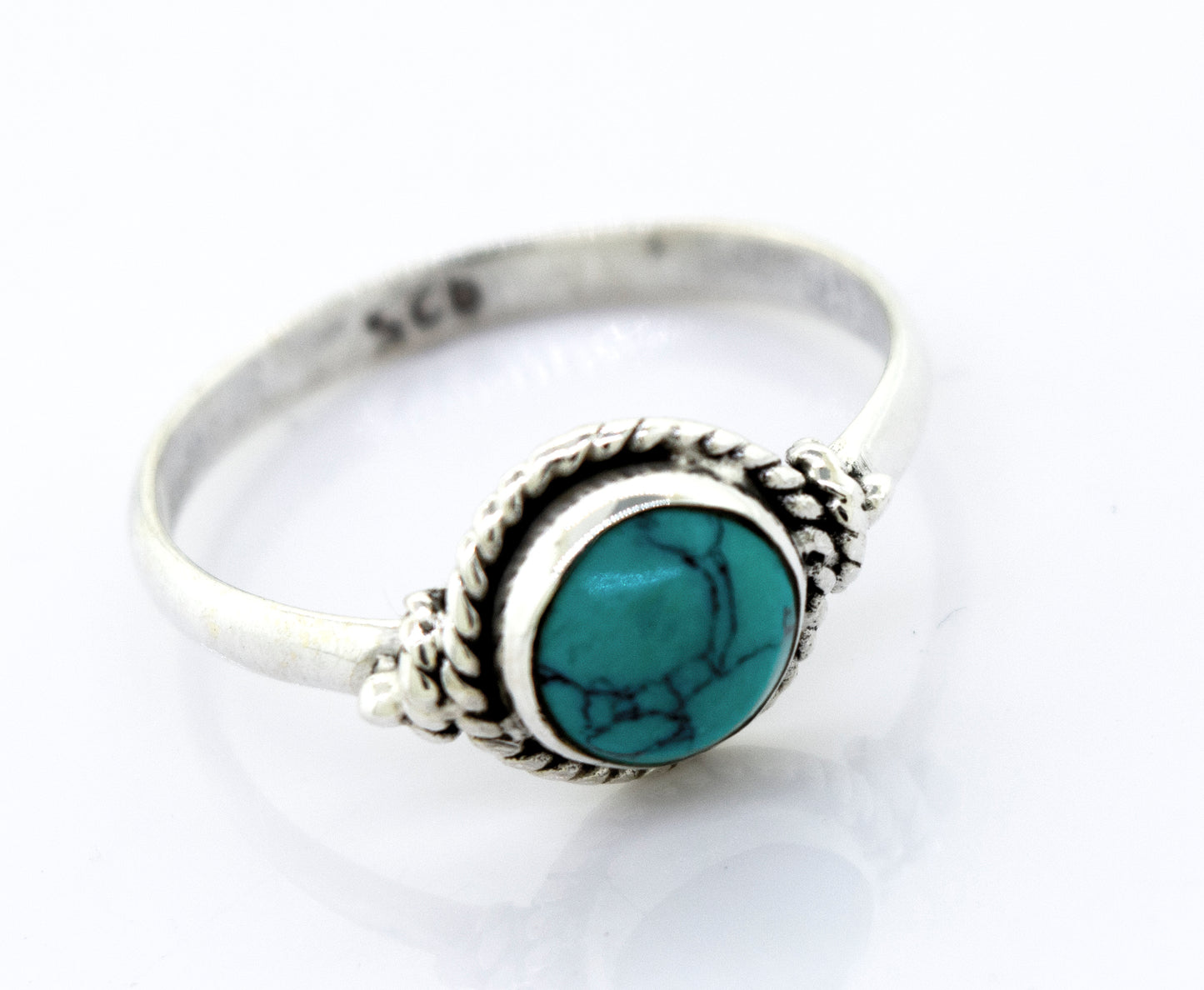 A Simple Round Turquoise Ring With Rope Border set in a Super Silver ring.