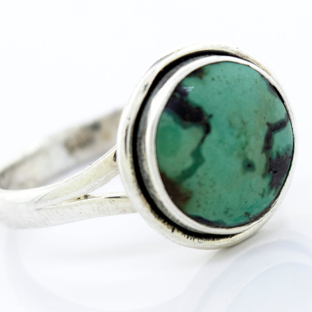 A Round Natural Turquoise Ring With Plain Border set in sterling silver.