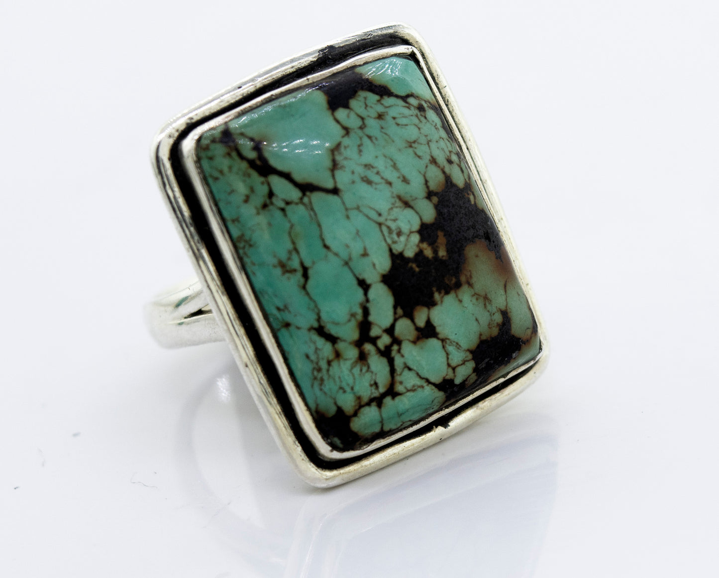 A Rectangular Natural Turquoise Ring With Plain Border set in a Super Silver ring.