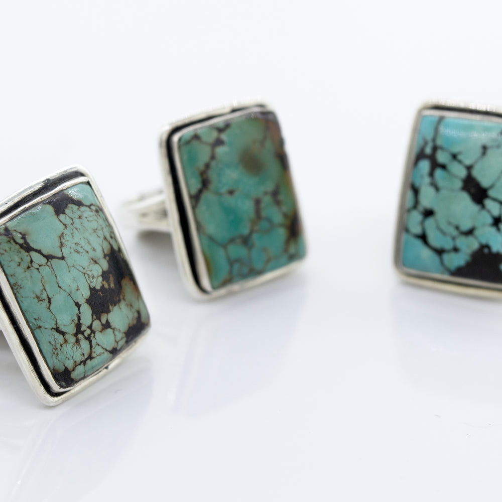 
                  
                    Three Rectangular Natural Turquoise Rings With Plain Border by Super Silver on a white surface.
                  
                