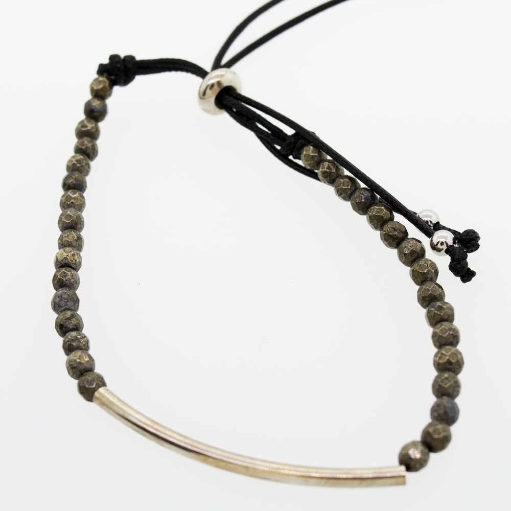 
                  
                    A Super Silver Adjustable Gemstone Bead Bracelet with a silver bar and a black cord.
                  
                