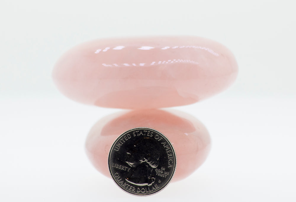 
                  
                    A Rose Quartz Worry Stone with a pink stone on top of it.
                  
                