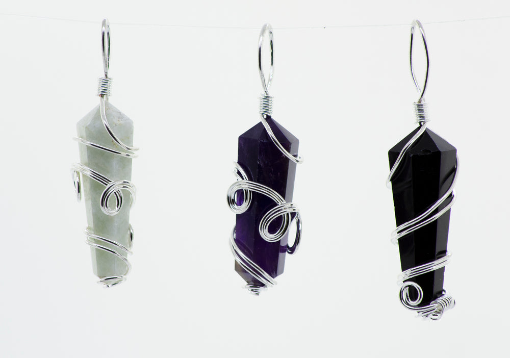 
                  
                    Three Super Silver wire-wrapped stone pendants hanging from a string.
                  
                