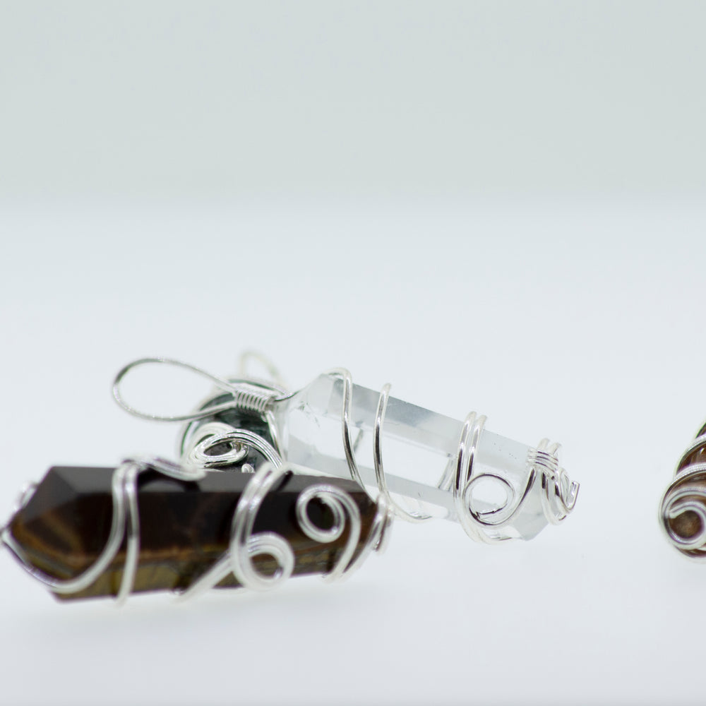 
                  
                    Three Super Silver Wire Wrapped Stone Pendants on a white surface.
                  
                