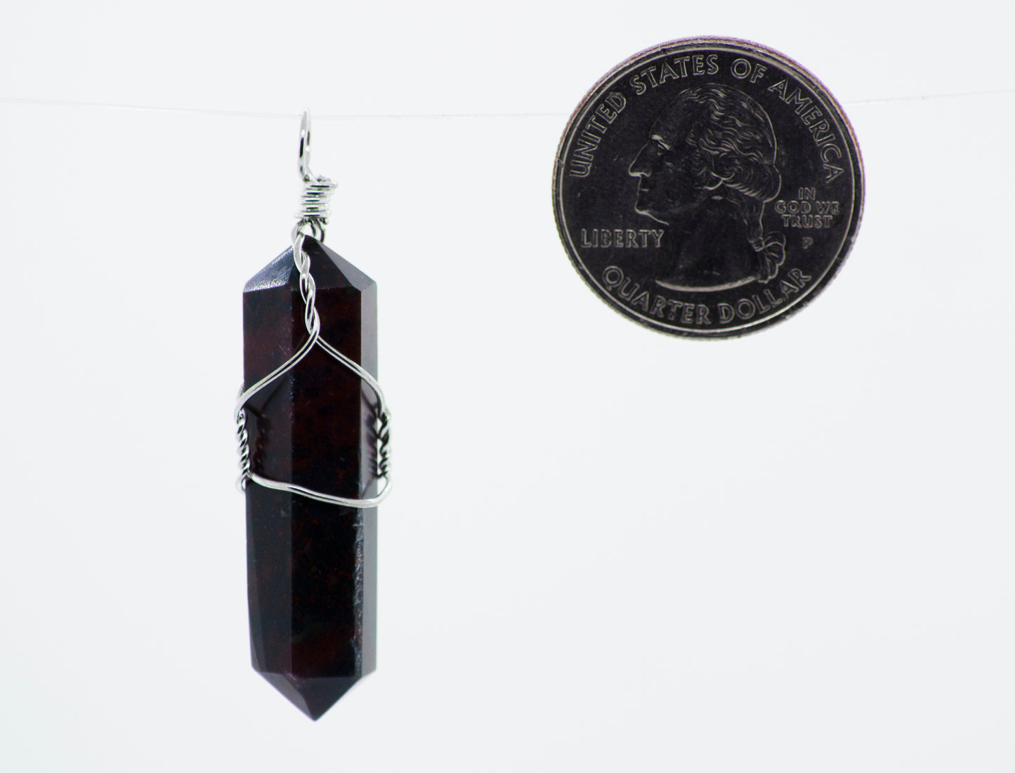 
                  
                    A Wire Wrapped Stone Pendant with a red garnet stone hanging from it, by Super Silver.
                  
                