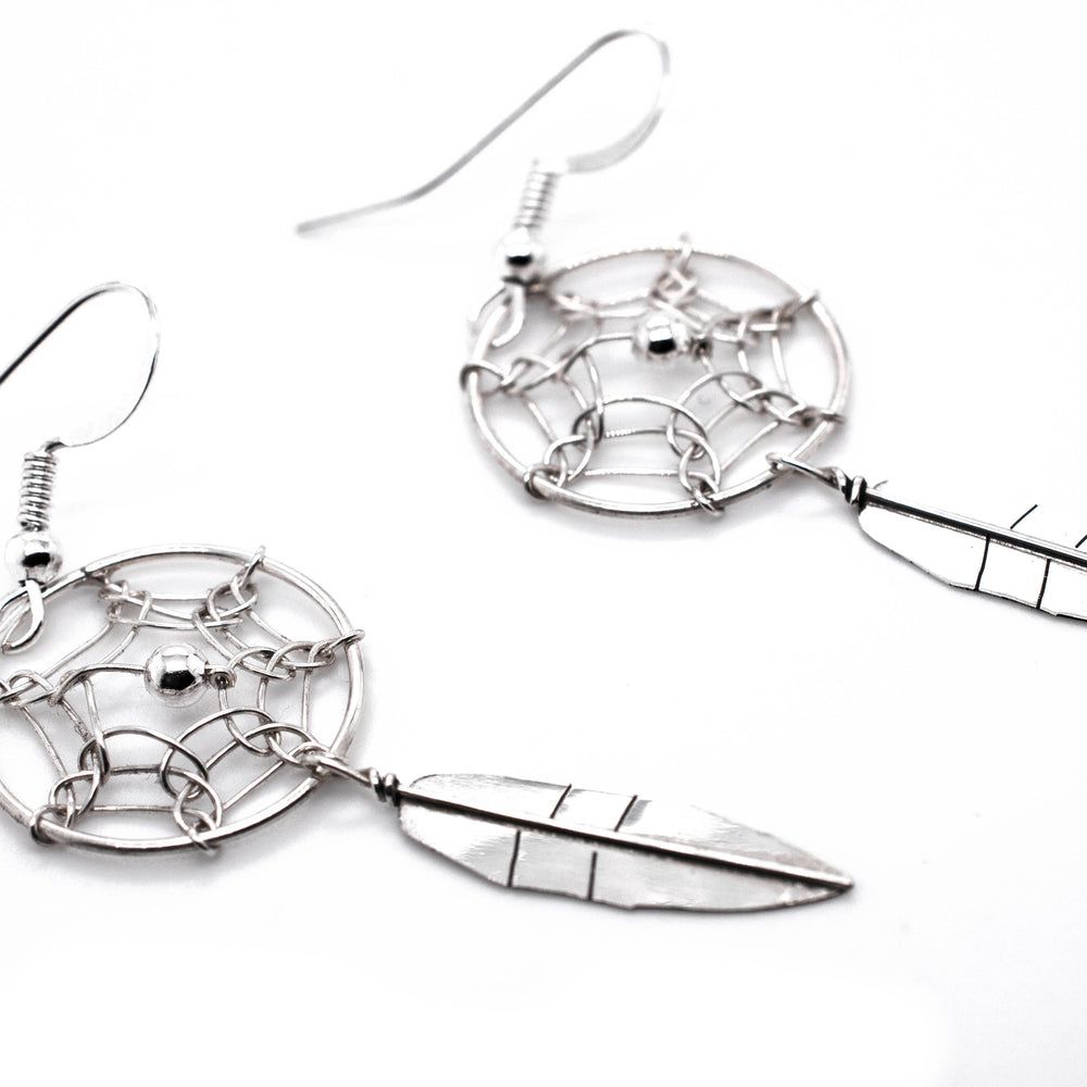 A pair of authentic Super Silver Zuni dreamcatcher earrings with feathers.
