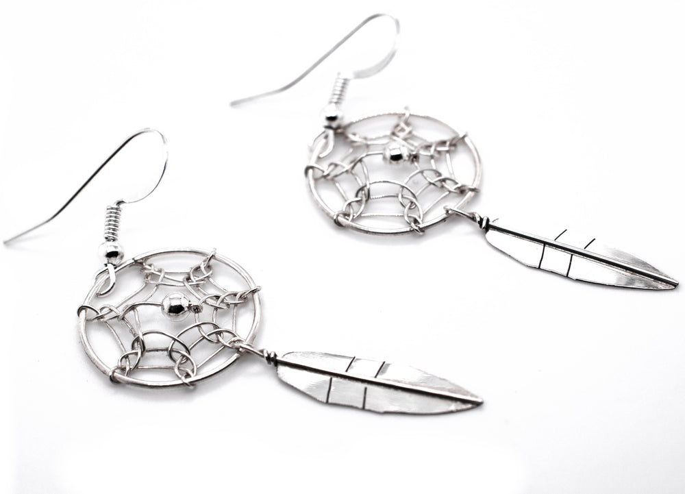 
                  
                    A pair of authentic Super Silver Zuni dreamcatcher earrings with feathers.
                  
                