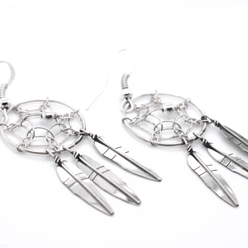 A pair of Stunning Zuni Dreamcatcher Earrings with boho charm on a white background by Super Silver.