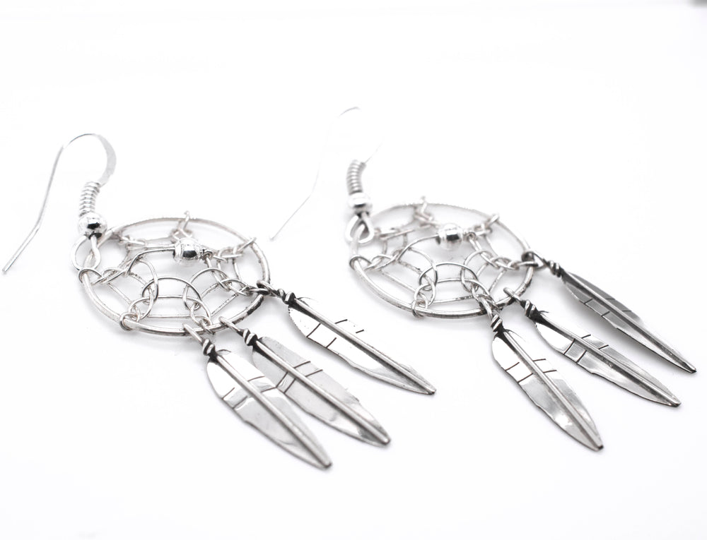 
                  
                    A pair of Stunning Zuni Dreamcatcher Earrings with boho charm on a white background by Super Silver.
                  
                