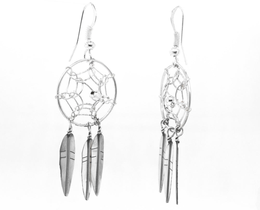 
                  
                    A pair of stunning Zuni Dreamcatcher earrings by Super Silver with feathers. These Zuni dreamcatcher earrings are beautifully adorned with silver feathers, creating a boho charm effect.
                  
                