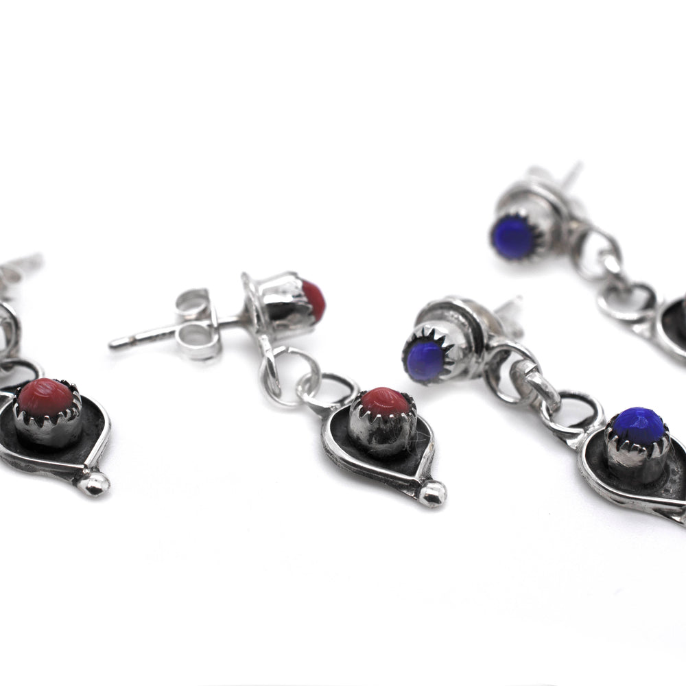 
                  
                    A pair of Delicate Zuni Lapis And Coral Earrings handmade by Super Silver with .925 Sterling Silver and adorned with blue and red stones.
                  
                