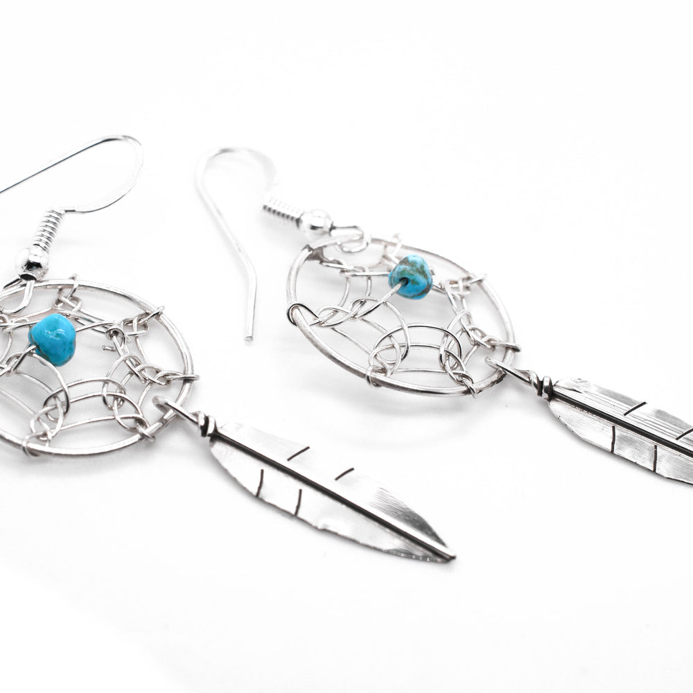 A pair of Zuni Dreamcatcher earrings with natural stone bead adorned with vibrant turquoise stones from Super Silver.