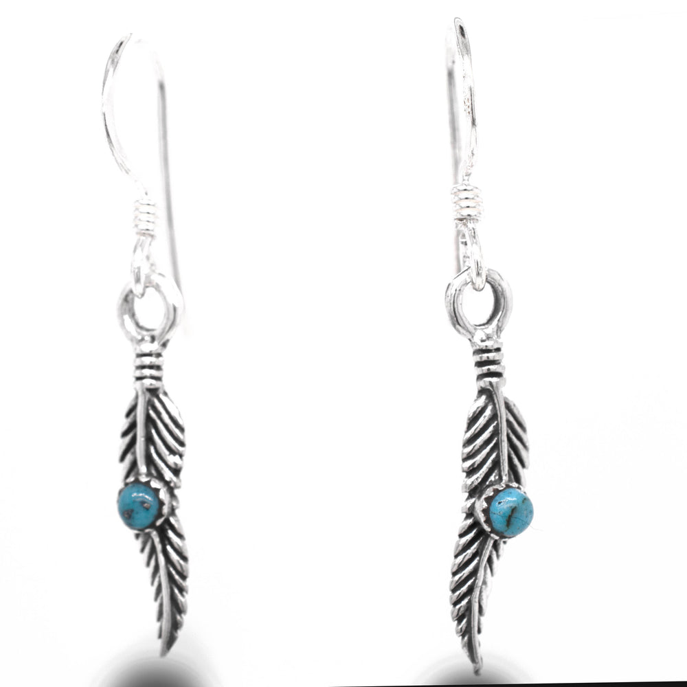 
                  
                    A stunning pair of Super Silver delicate feather earrings adorned with vibrant turquoise stones.
                  
                